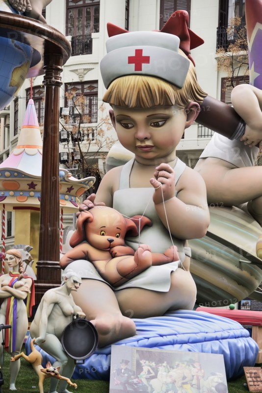 Spain, Valencia Province, Valencia, Papier Mache figure of young girl in nurses outfit with teddy bear in the street during Las Fallas festival. 
Photo Hugh Rooney