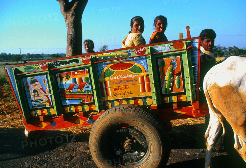 Famille rentrant à la maison dans une charette multicolore, sud du Karnataka, Inde.