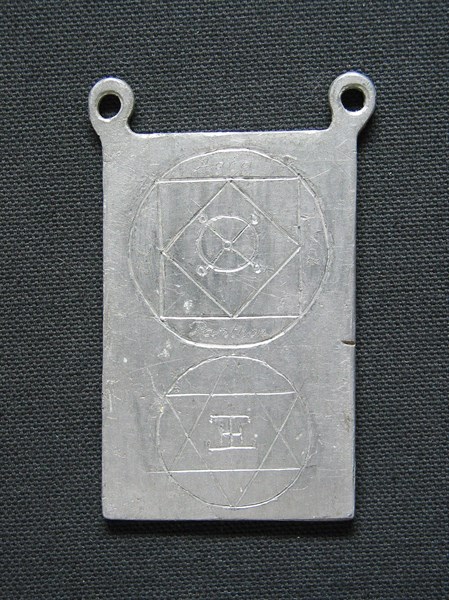 Lead amulet engraved with esoteric signs.
