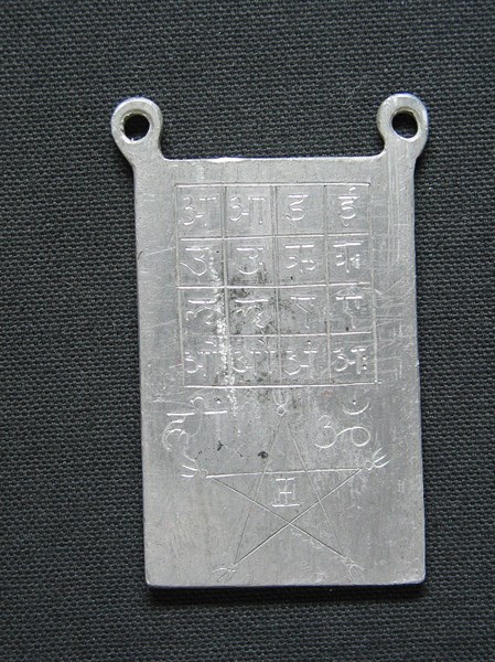 Lead amulet engraved with esoteric signs.