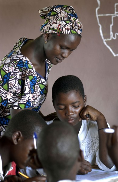 Institutrice africaine corrigeant les cahiers d'un élève, 2004