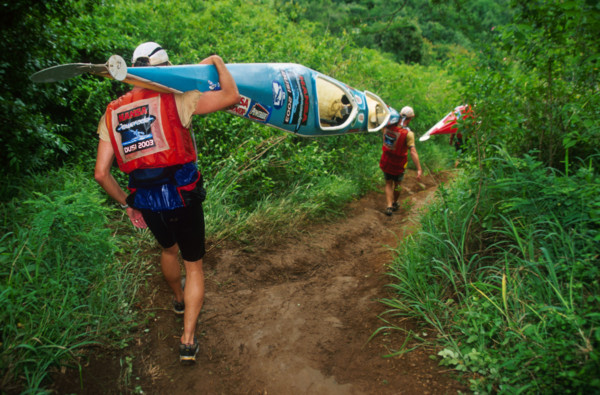 double canoe descending steep path through lush vegetation