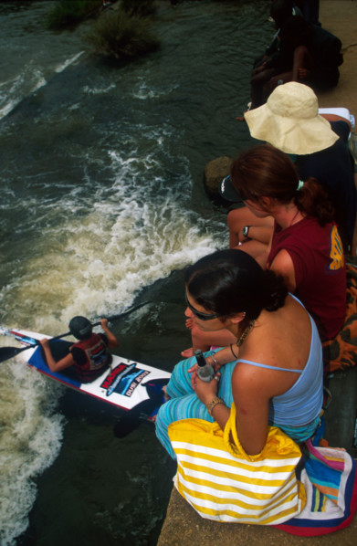 girls on bridge, paddler below