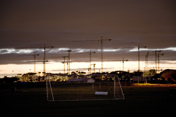 Seen from soccer fields in Greenpoint, construction cranes rise above the site of the new