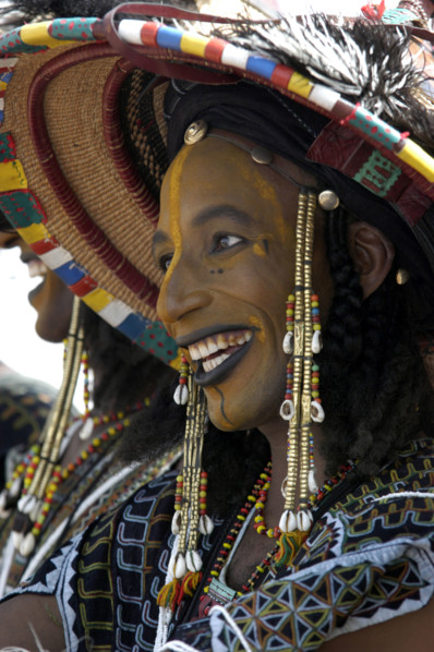 A Wodaabe man performs a dance of male beauty, showing off the whiteness of his teeth and eyes at a