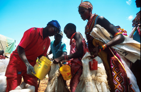 Solomon Gitonga, an aid worker with EdFri International measures out grain for Samburu women and girls