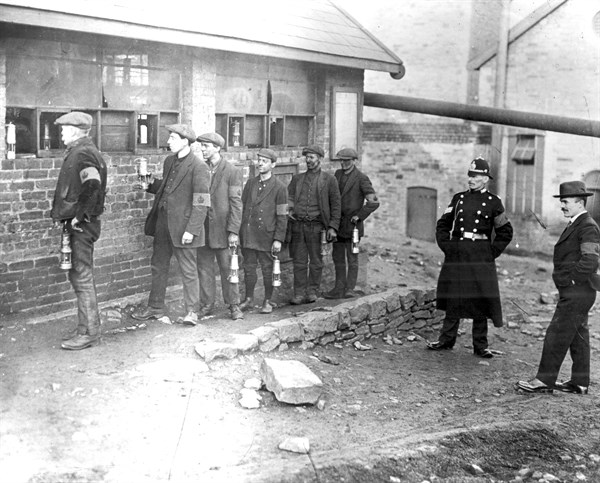Strike-breaking coal miners in the Rhondda Valley, Wales, with their lamps before going down the
