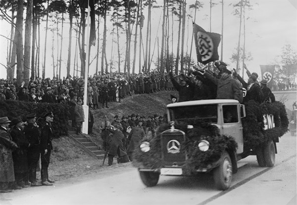 Men standing in the back of a truck salute Hermann Göring, 1936