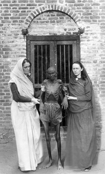 Photographic print of an emaciated famine victim standing with Miss Neil and an unidentified woman