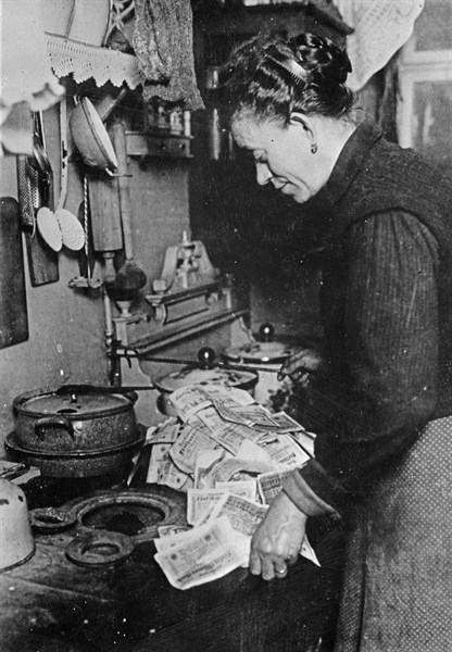 German woman starting a fire with a pile of marks