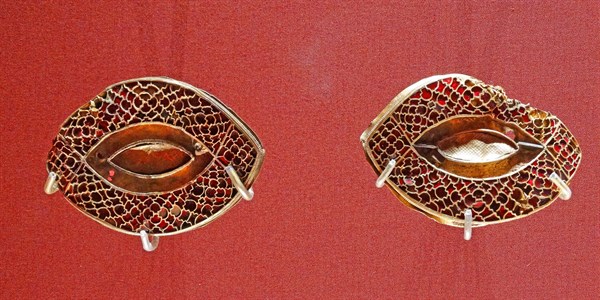 Anglo Saxon metalwork; 5th-6th Century AD. Pair of eye-shaped mounts, with cloisonné garnets
