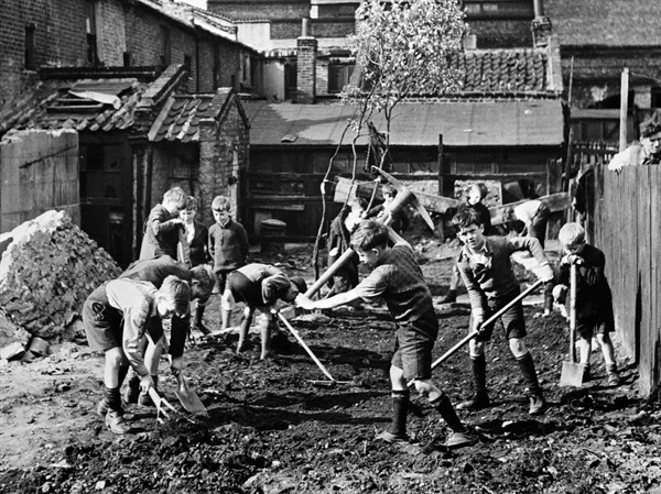 Boys clear away the debris in England, World War Two, 1943