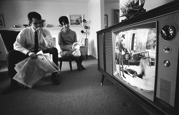 American man and woman watching news footage of the Vietnam war
