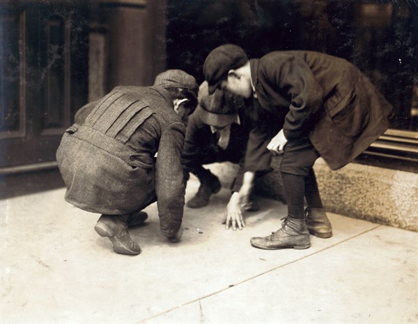 Photograph of children pitching pennies on the Main St. Fall River, Massachusetts