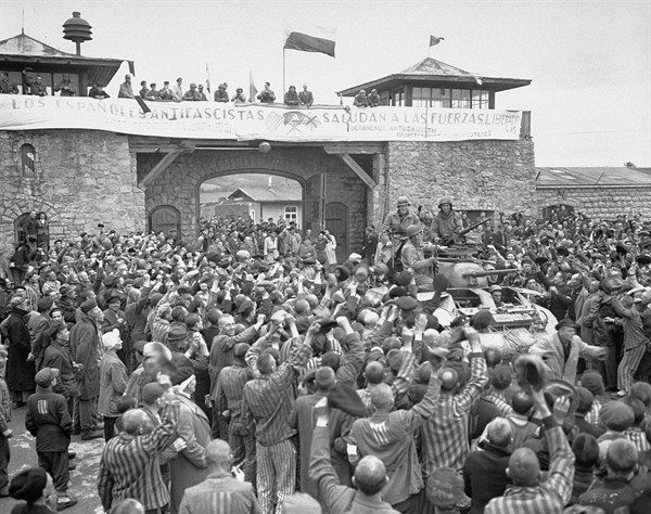 Tanks of U.S. 11th Armoured Division entering the Mauthausen concentration camp;banner in Spanish reads 'Antifascist Spaniards greet the forces of liberation'. The photo was taken on 6 May 1945