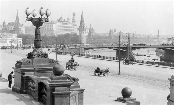 Photograph of horse-drawn wagons and motor trucks
