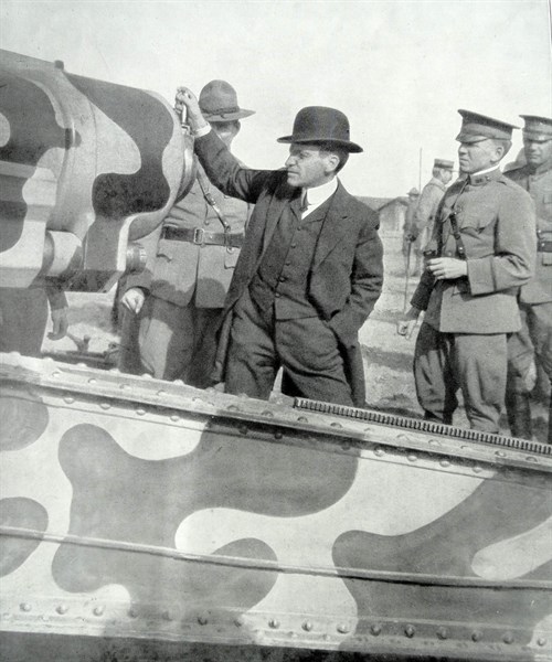 US Secretary of war visits a camouflaged artillery gun in France in WWI.