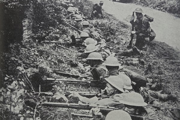 Photograph of Soldiers taking up position by the roadside