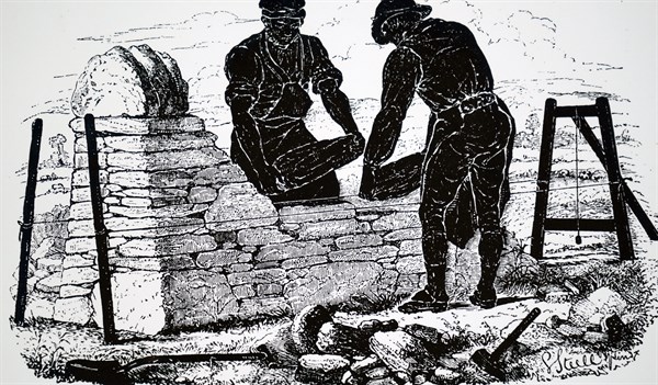 Two labourers building a dry stone wall somewhere in the English countryside