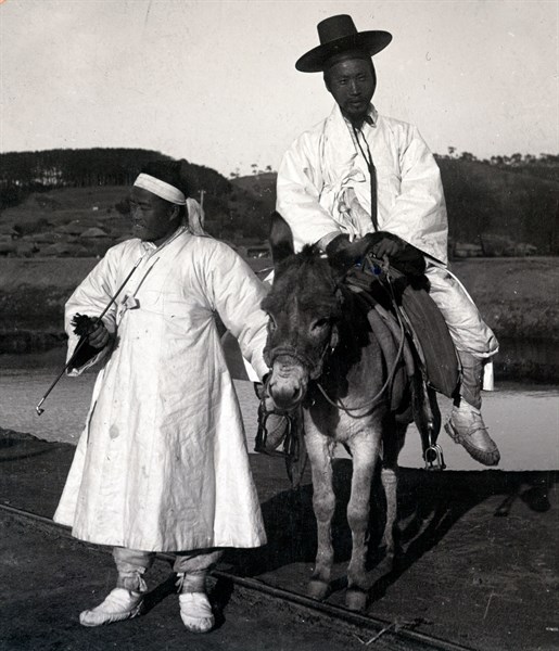 Korean official on a donkey led by a servant. Joseon Era. Circa 1900