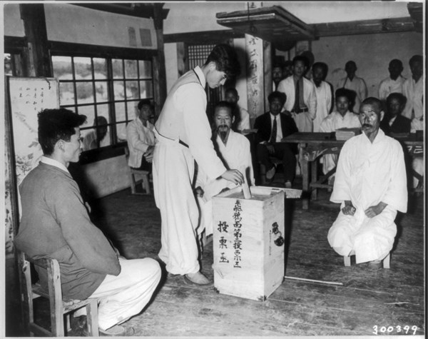A Korean citizen drops a vote into ballot box during the first democratic election in Nae Chon, Korea