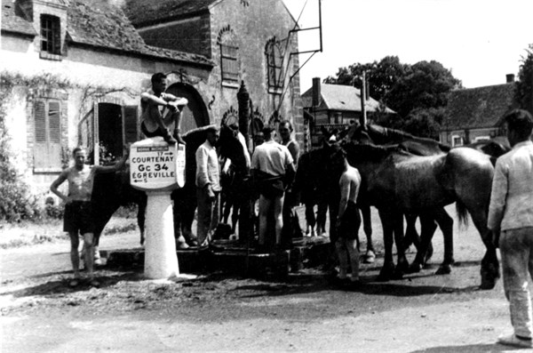 Soldats allemands faisant leur toilette dans la fontaine d'un village près de Courtenay, 1940