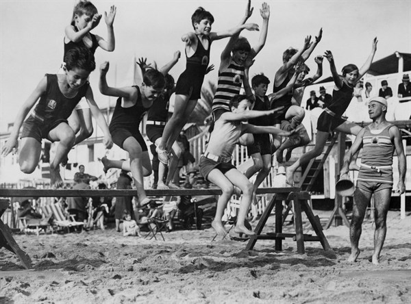 Young bathers jump over hurdles on Cannes beach