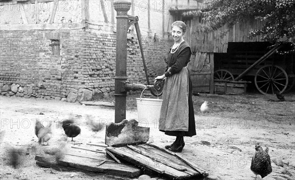 Farmer's wife gets water from a water pump