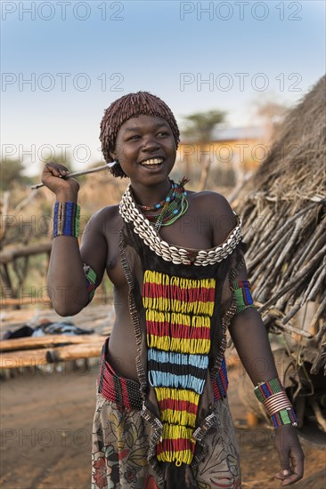Young girl in traditional dress with necklace and spear