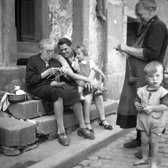 Mother and children shy away from the grandparents while knitting