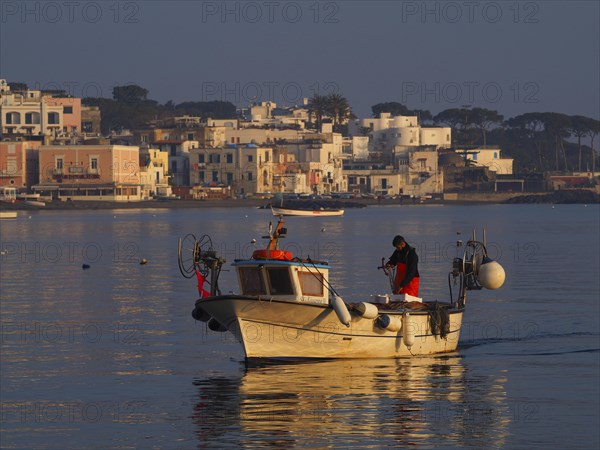 Fisherman early in the morning on his boat in the harbour