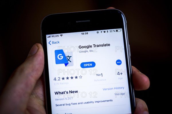 Hand holding iPhone with Google Translate App in the Apple App Store