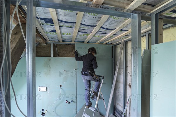 Young woman renovating the attic in an old house