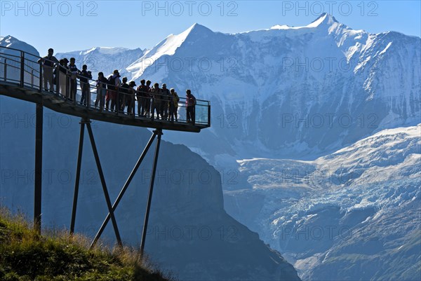 Tourists on the observation deck of the First Cliff Walk by Tissot in front of the Fiescherhorn north face and the Grindelwald glacier