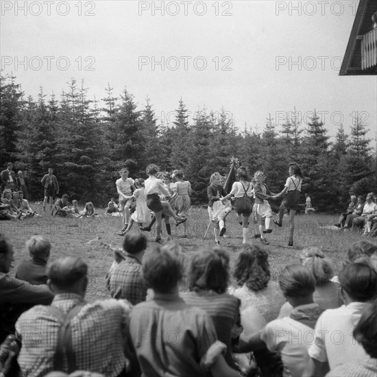 Children dance in a meadow