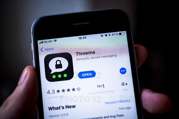 Hand holding iPhone with Threema