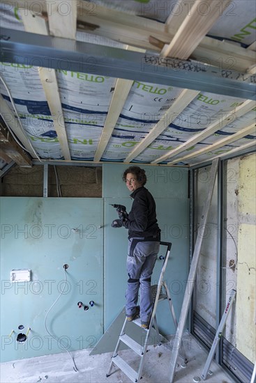 Young woman renovating the attic in an old house