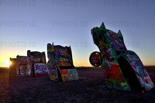 Sunset behind painted Cadillacs
