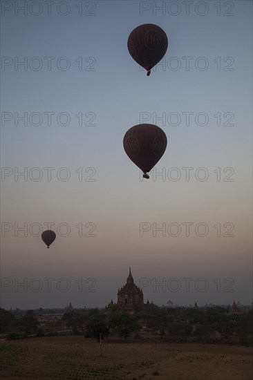 Hot air balloons at sunrise over temples and pagodas