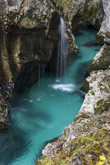 Emerald green wild river Soca flows through rocky gorge