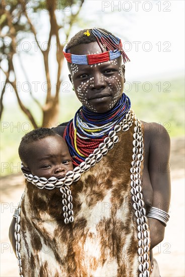 Young woman with toddler in traditional clothes made of goatskin