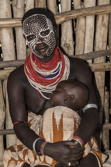 Young woman with painted face and baby
