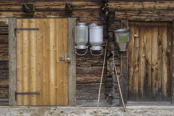 Milk pots hanging on stable wall