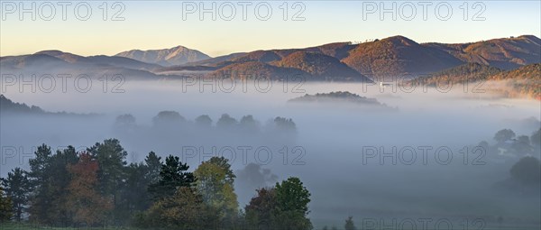 Autumn foggy atmosphere with Schneeberg and pilgrimage church Hafnerberg