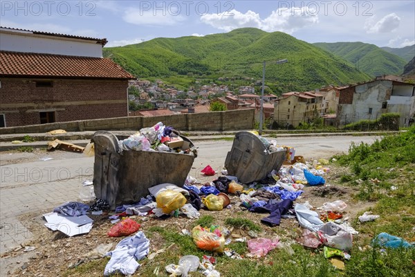 Garbage and full garbage containers on the roadside