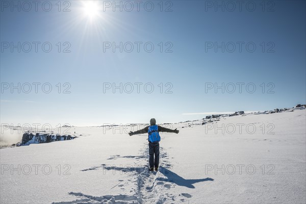 Young man walks through snowy countryside