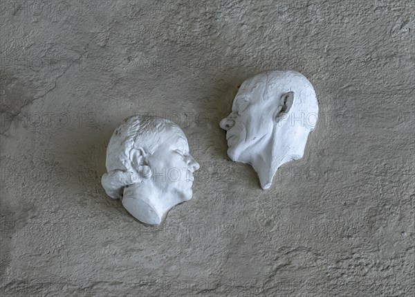 Plaster busts of Liesl Karlstadt and Karl Valentin over the entrance of the Karl Valentin Musaum