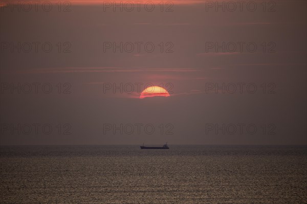 Mediterranean sea with cargo ship in the sunset at Tarragona