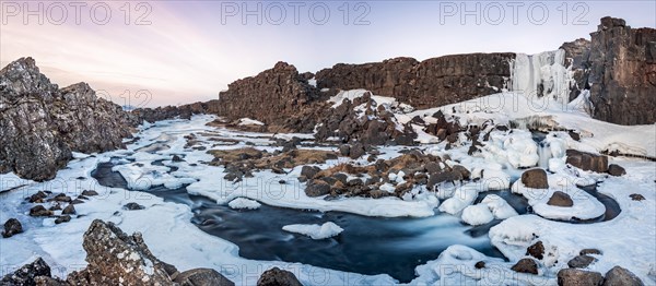 Partially frozen waterfall Oxararfoss in winter
