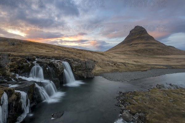 Kirkjufell mountain with Kirkjufellfoss waterfall at sunset